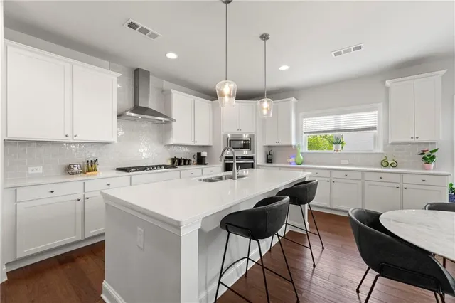 a kitchen with a dining table chairs sink and cabinets