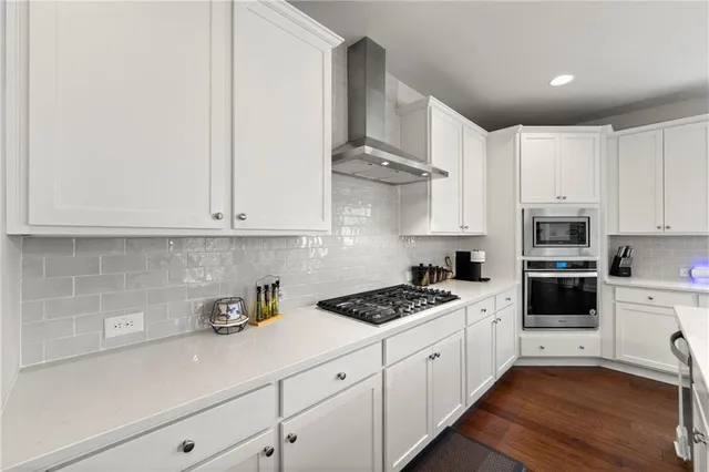 a kitchen with white cabinets and appliances
