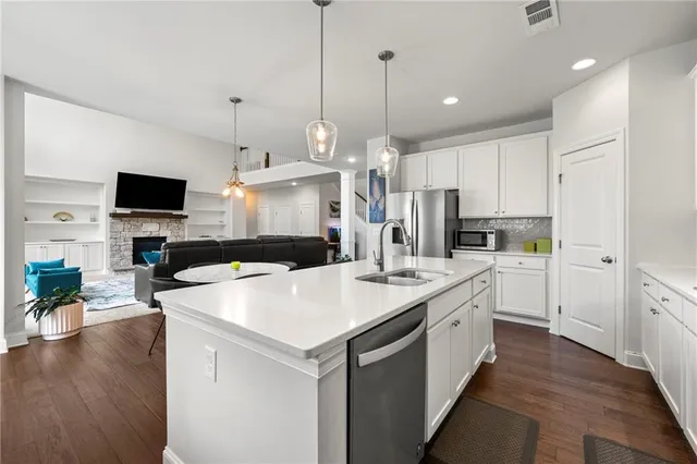 a kitchen with a sink a counter top space stainless steel appliances and a center island