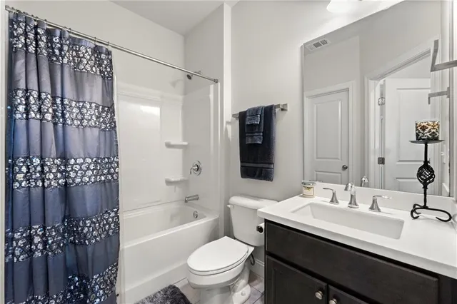 a bathroom with a sink a toilet a mirror a vanity and shower