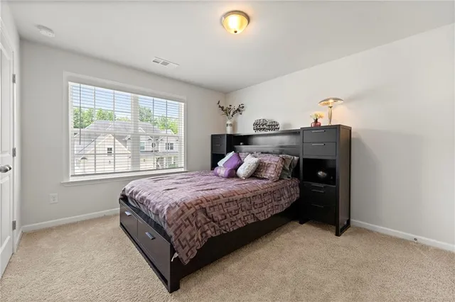a bed sitting in a bedroom next to a window