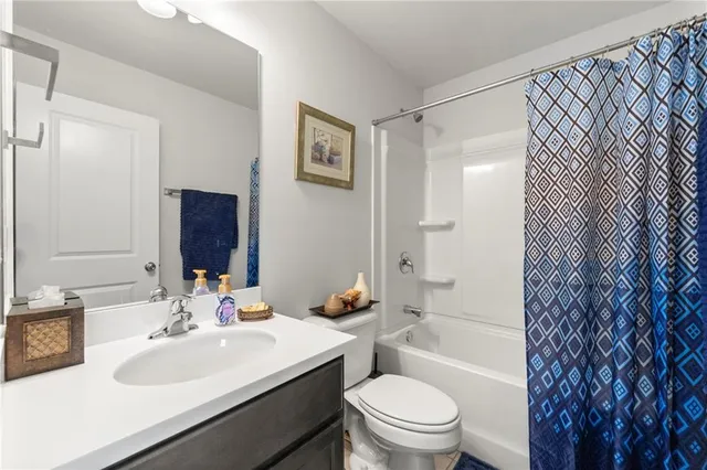 a bathroom with a sink toilet vanity and shower