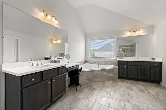 a large bathroom with a double vanity sink mirror and bathtub
