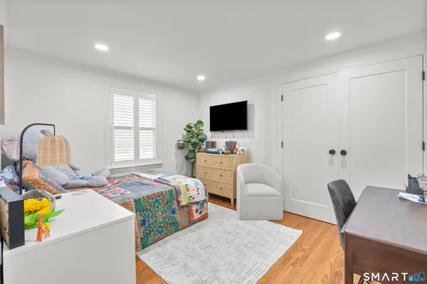 a bedroom with a bed and a flat screen tv