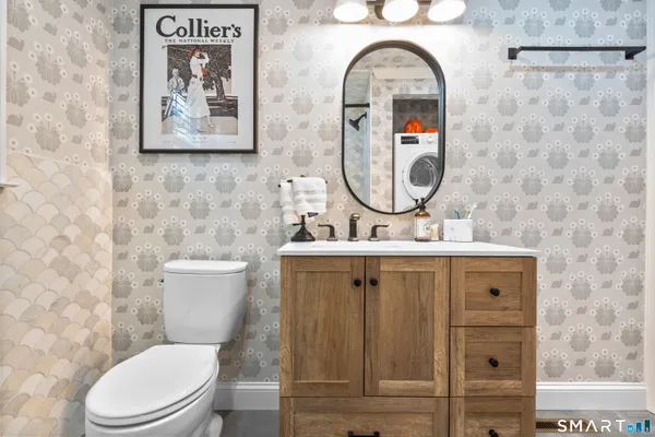 a bathroom with a toilet a sink and mirror