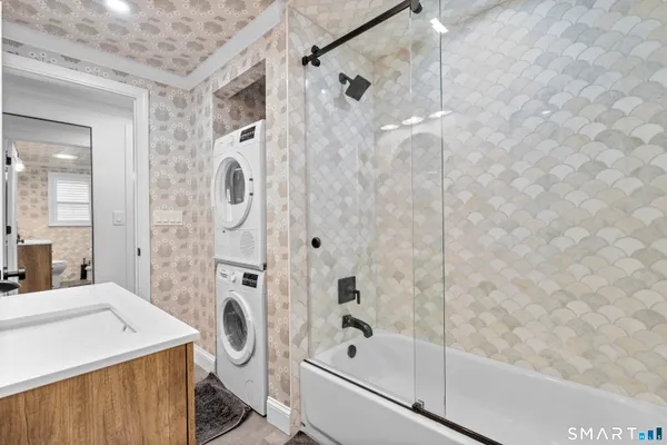 a bathroom with a granite countertop sink a toilet and shower