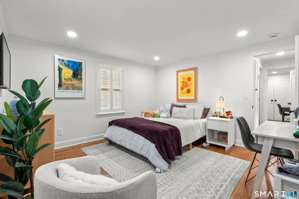 a bedroom with a bed and a potted plant