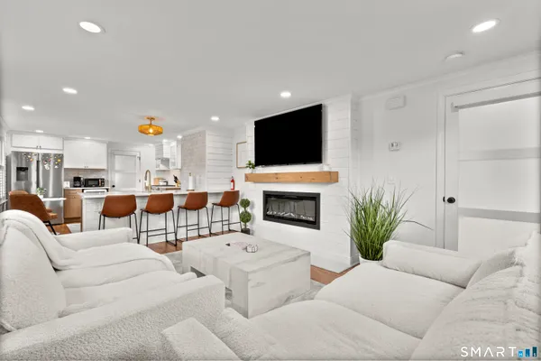 a living room with furniture a fireplace and a flat screen tv