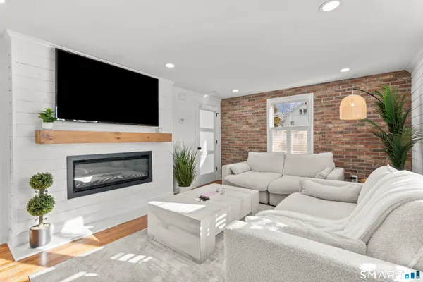 a living room with furniture a fireplace and a flat screen tv