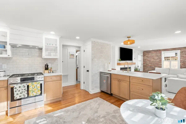a kitchen with stainless steel appliances kitchen island granite countertop a sink and a stove