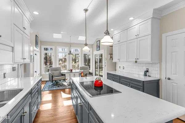 a kitchen with kitchen island a sink stainless steel appliances and white cabinets