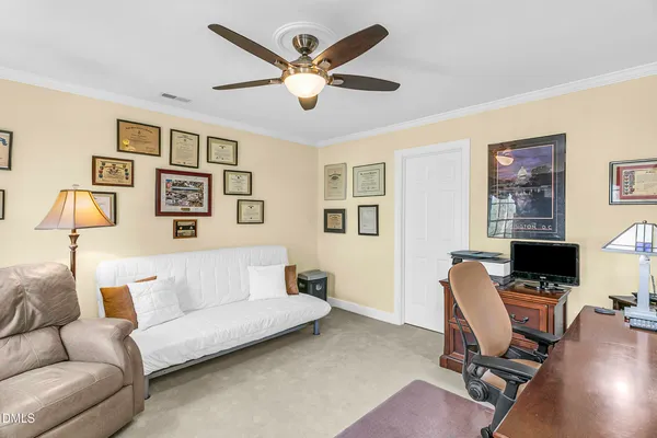 a view of a house with a small yard and wooden fence