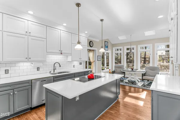 a kitchen that has a lot of cabinets and wooden floor