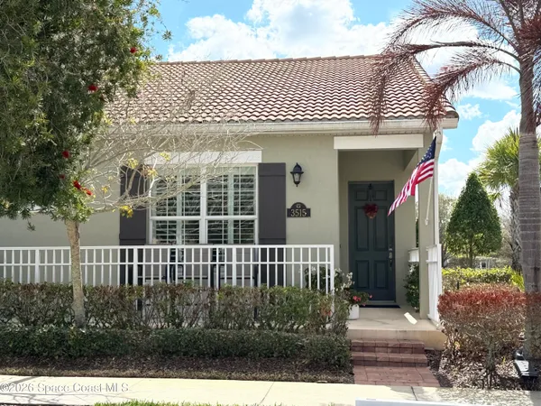a view of a house with a small yard and wooden fence