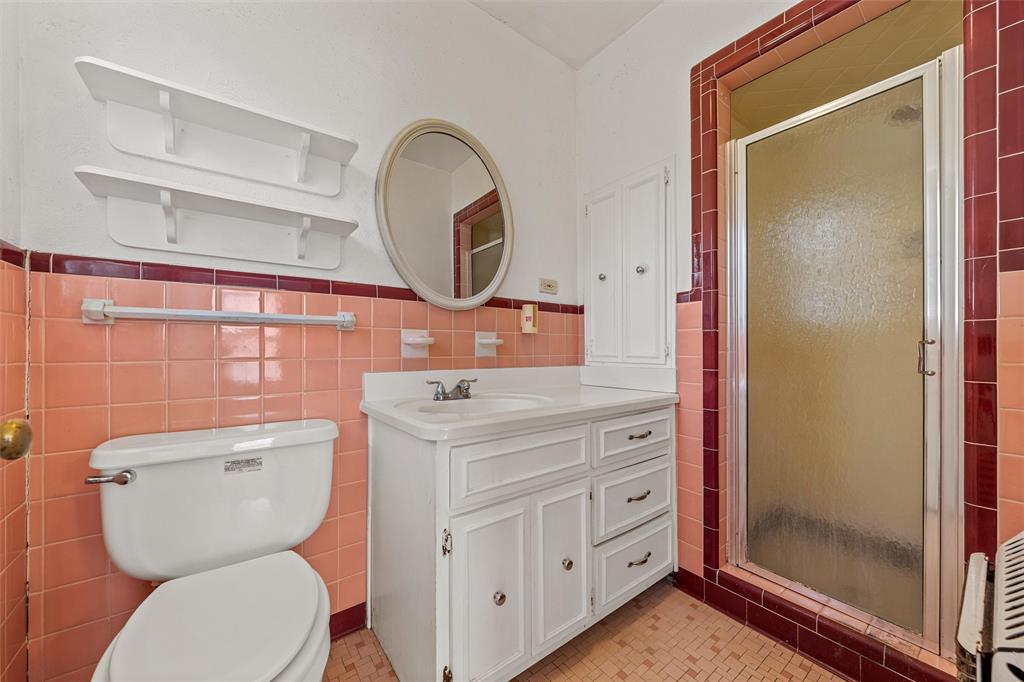 3117 Colcord Avenue Waco, TX 76707 - Photo 14 of 26 a bathroom with a toilet a sink and a mirror