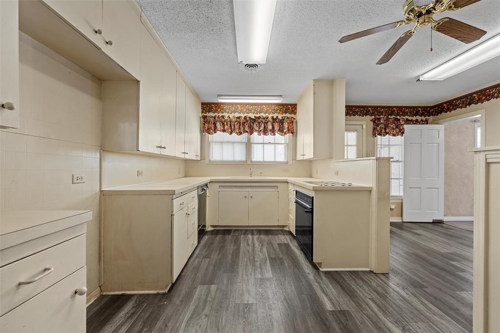 3117 Colcord Avenue Waco, TX 76707 - Photo 6 of 26 a kitchen with a white cabinets and wooden floor