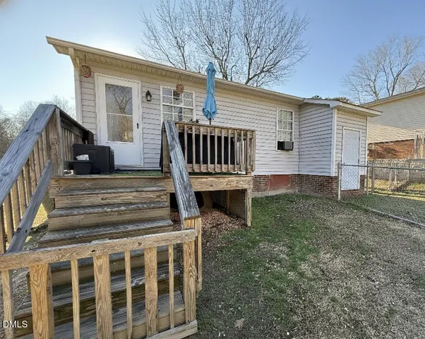 a view of a house with backyard and wooden fence