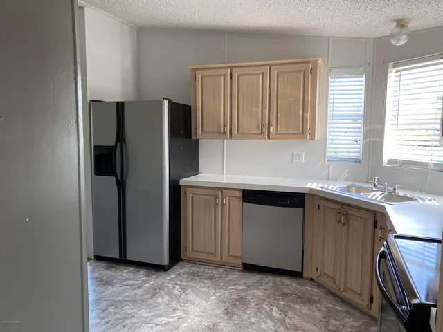 a kitchen with stainless steel appliances granite countertop a refrigerator and a sink