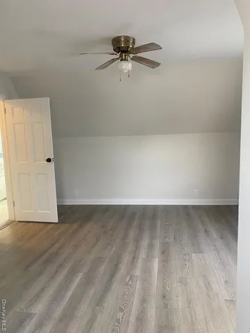 a view of a room with wooden floor and a ceiling fan