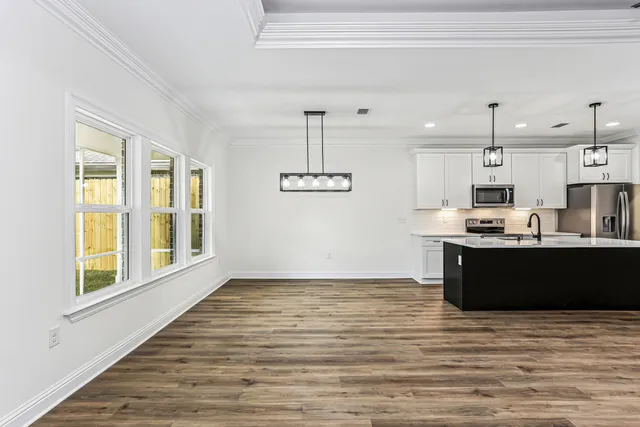 a kitchen with a sink a chandelier and wooden floor