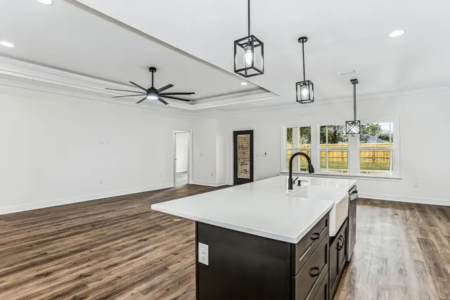 a kitchen with kitchen island granite countertop a sink a counter space appliances and cabinets