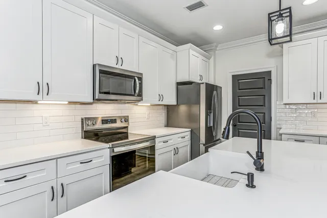 a kitchen with a sink stainless steel appliances a sink and cabinets