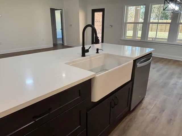 a kitchen with kitchen island granite countertop a sink stainless steel appliances and white cabinets