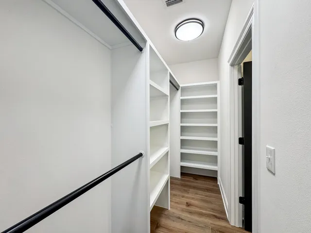 a view of walk in closet with empty racks