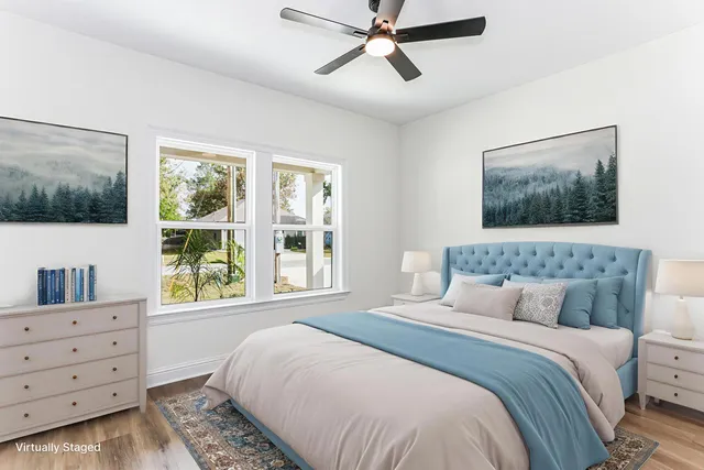 an empty room with wooden floor ceiling fan and windows