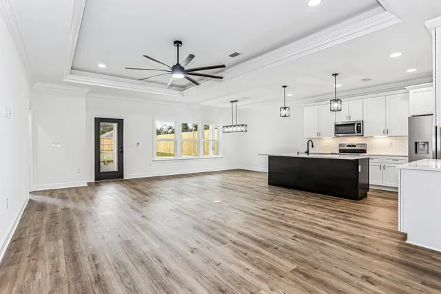 a living room with furniture a flat screen tv and a window