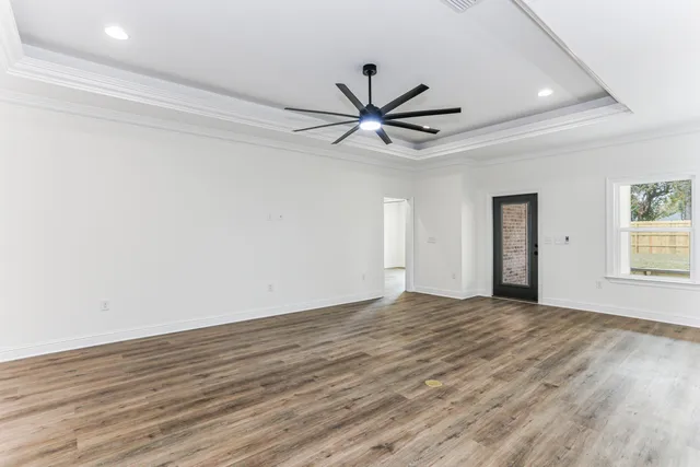 a view of an empty room with a ceiling fan and window