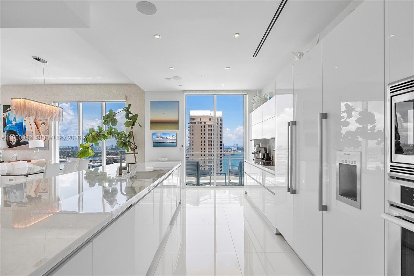 900 Brickell Key Boulevard, Unit 3103 Miami, FL 33131 - Photo 14 of 54 a large white kitchen with a lot of counter space and glass door