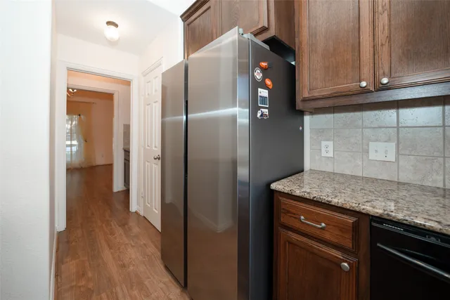 a kitchen with stainless steel appliances granite countertop a refrigerator and a sink