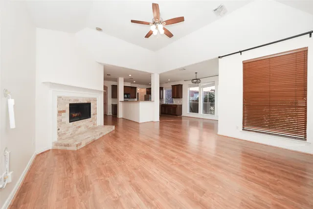 an empty room with ceiling fan and window