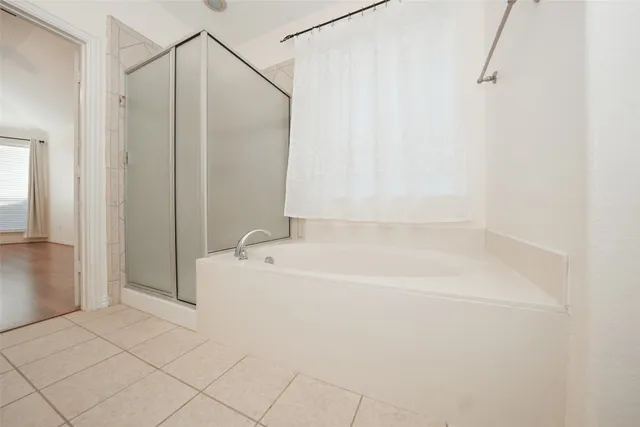 a spacious bathroom with a shower a mirror and a sink