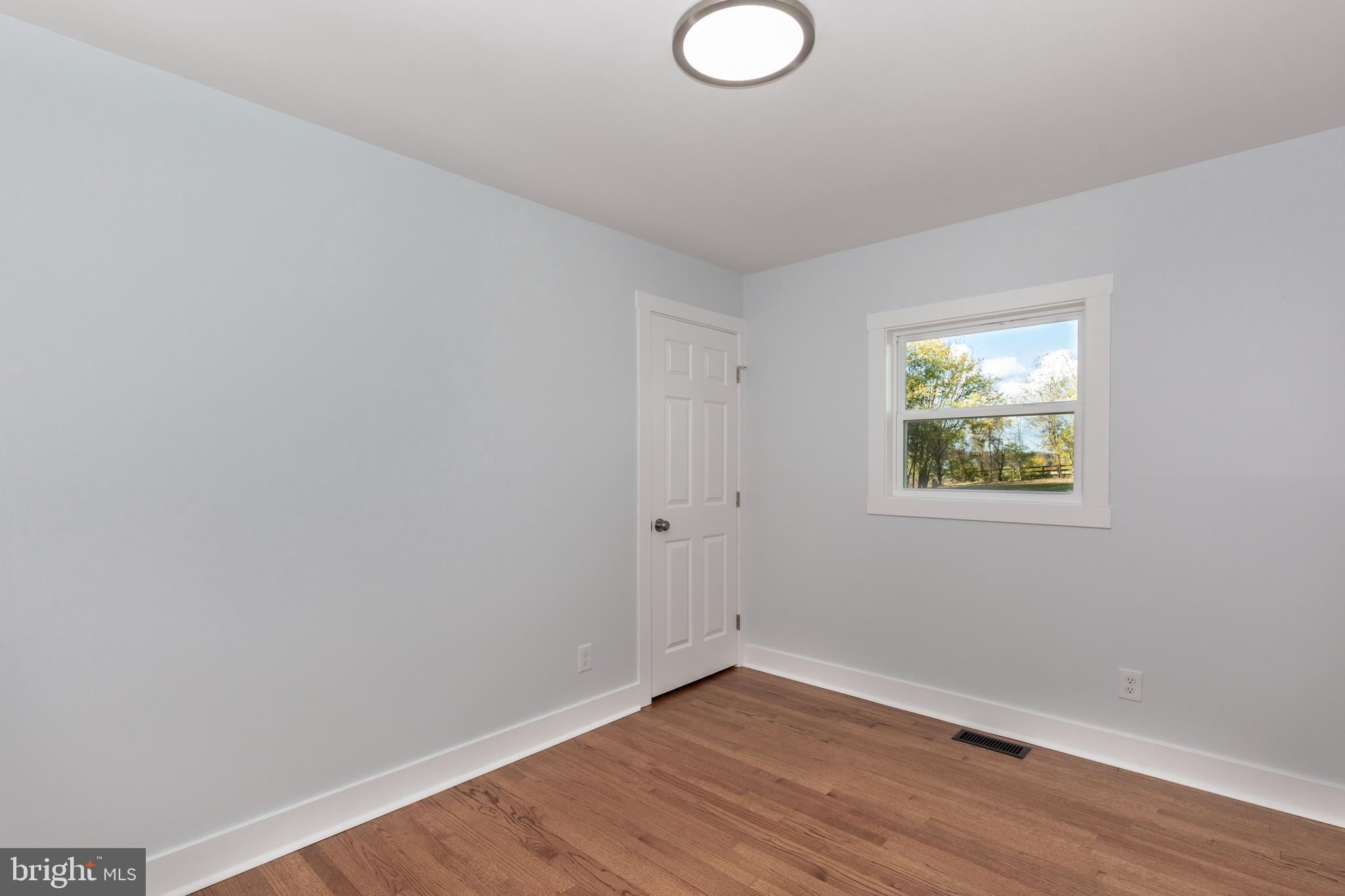 1030 Mckinstrys Mill Road Union Bridge, MD 21791 - Photo 14 of 43 a view of an empty room with wooden floor and a window