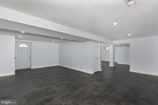 an empty room with closet and windows