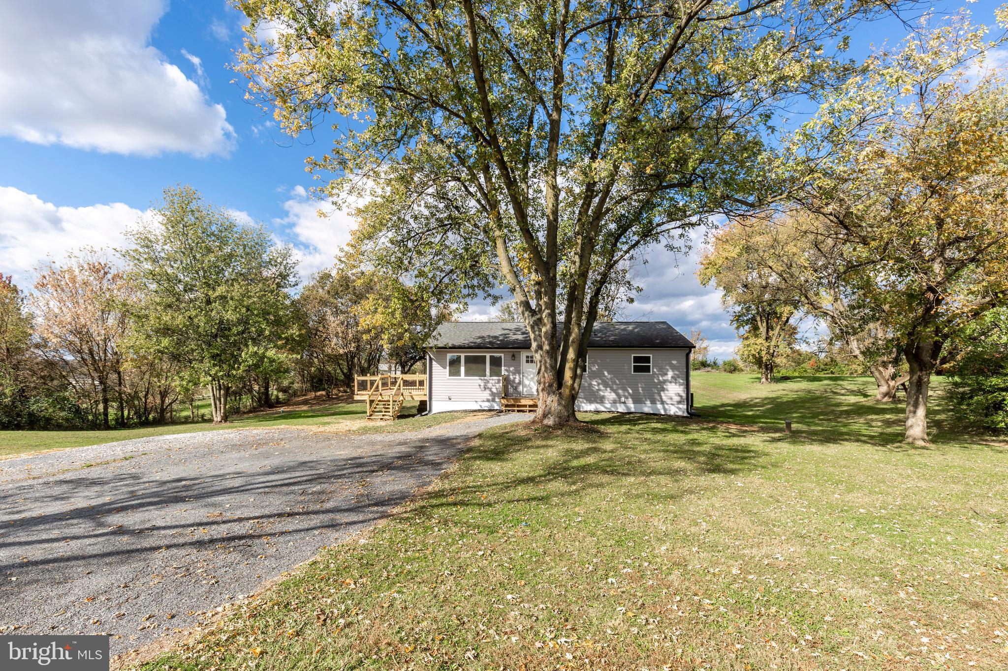 1030 Mckinstrys Mill Road Union Bridge, MD 21791 - Photo 40 of 43 a yellow house with a big yard plants and large trees