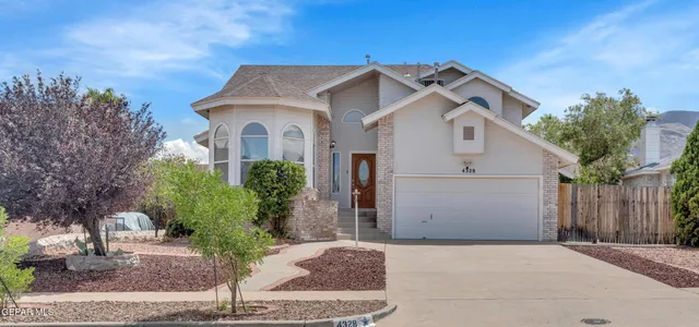 a view of a white house with a clock and a large tree