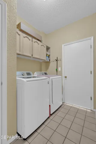 a utility room with cabinets washer and dryer