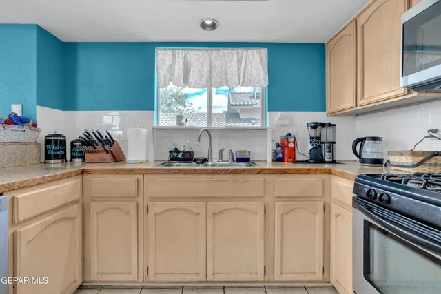 a kitchen with white cabinets and white appliances