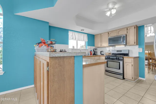 a kitchen with granite countertop a sink cabinets stainless steel appliances and a window