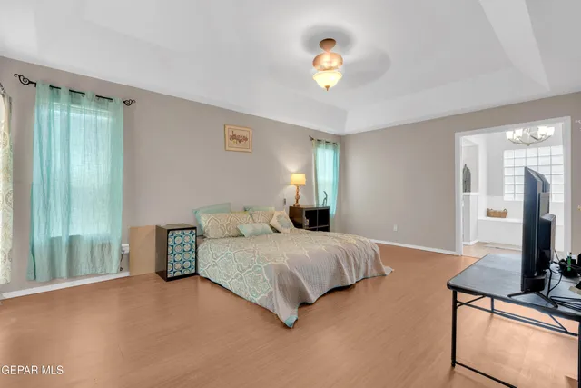 a bedroom with a bed and a flat tv screen on dresser