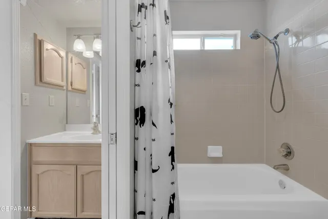 a bathroom with a bathtub a shower and a mirror