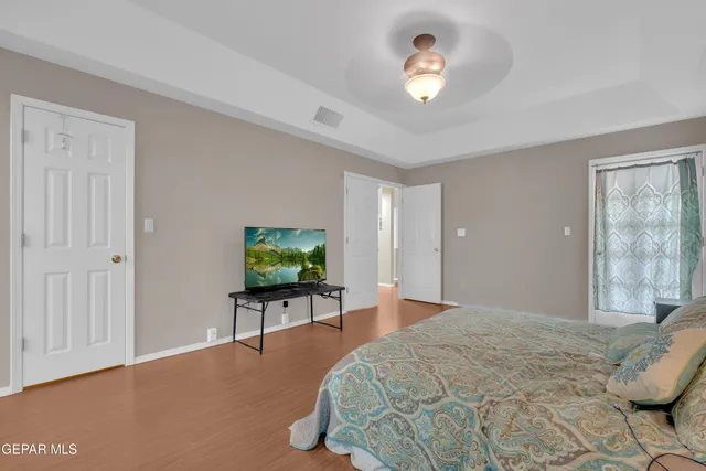 a bedroom with a bed and a flat tv screen on dresser