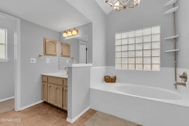 a bathroom with a tub sink and mirror