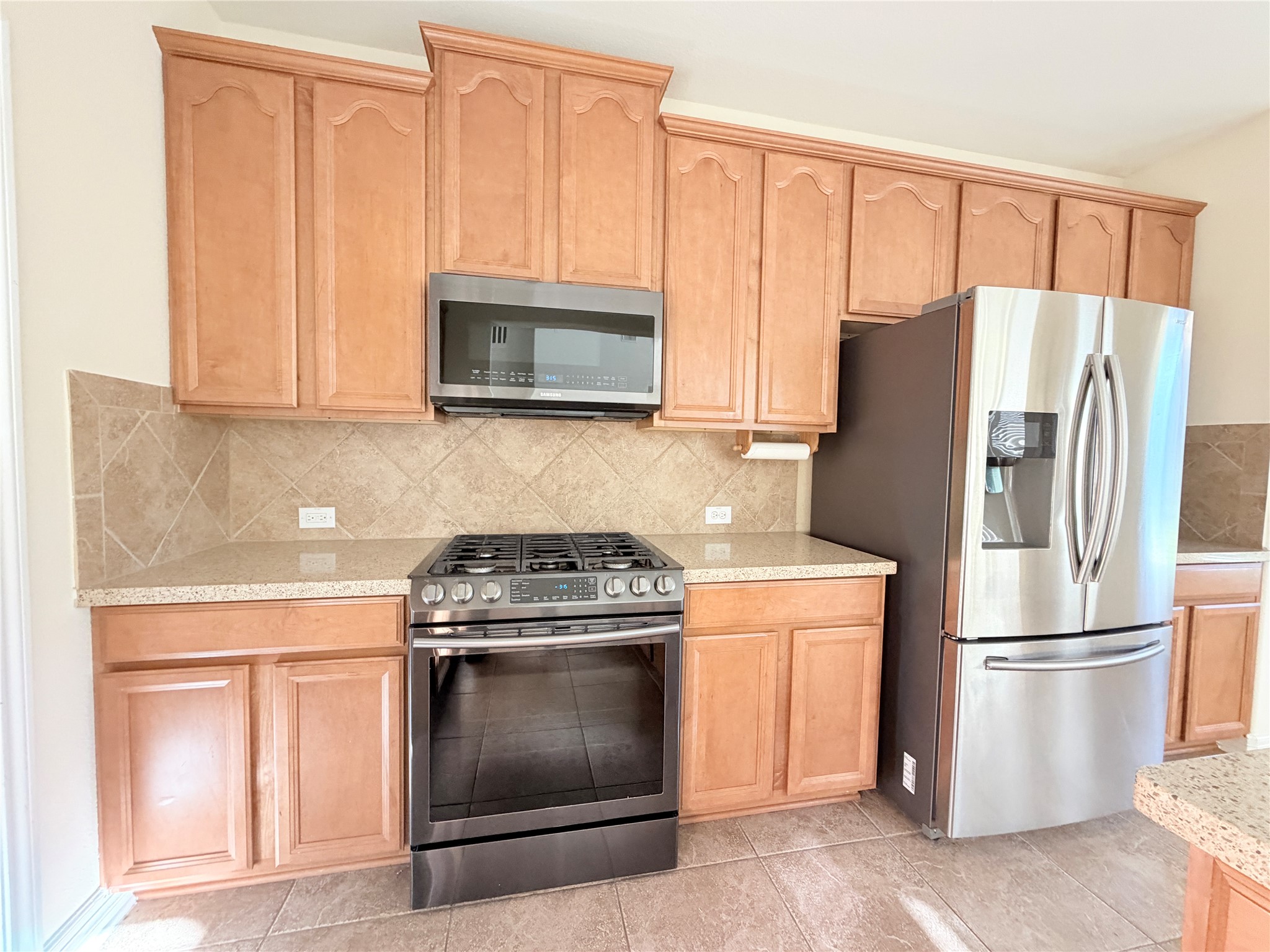 28015 Silverstream Court Fulshear, TX 77441 - Photo 7 of 33 a kitchen with a stove microwave and refrigerator