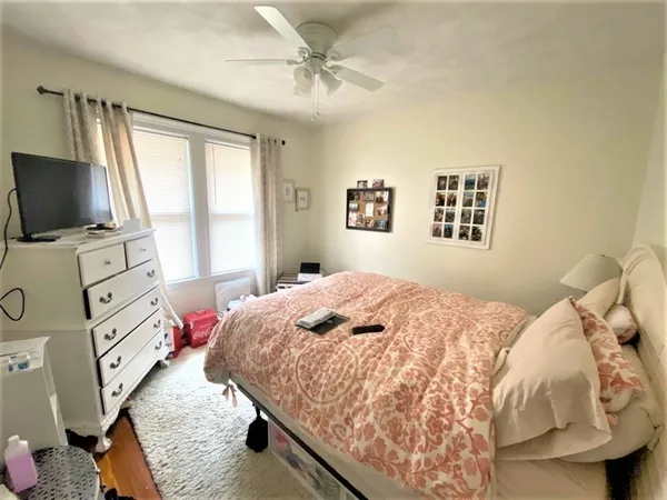 a bedroom with a bed dresser and flat screen tv