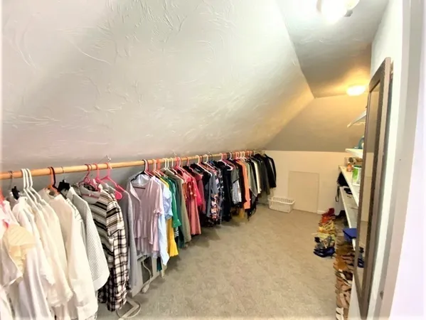a view of walk in closet with clothes and shoes