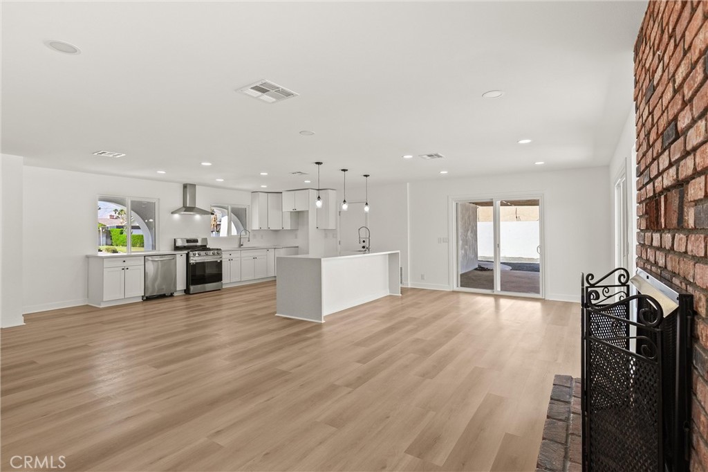 2852 East San Angelo Road Palm Springs, CA 92262 - Photo 11 of 25 a view of a kitchen with kitchen island a sink wooden floor and a counter top space
